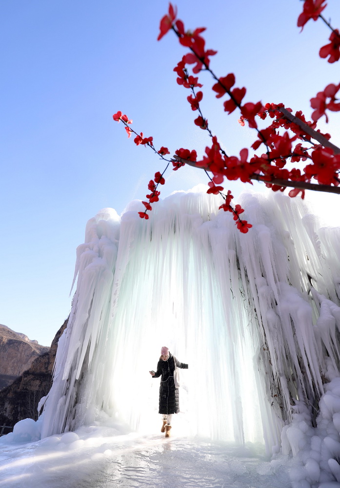 12月16日，在河北省平山縣沕沕水景區(qū)，游客在冰瀑中穿梭游玩。