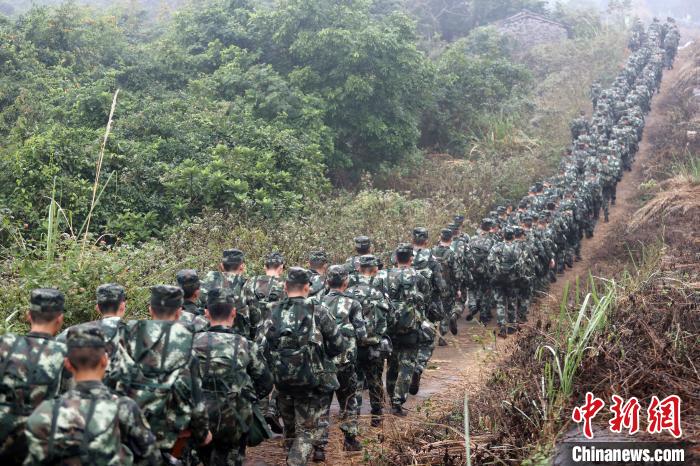 拉練官兵在田間小路行軍?！±邹H 攝