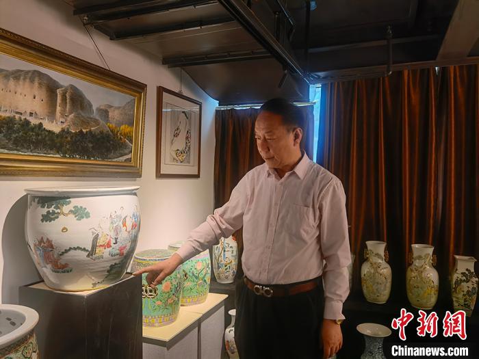 劉世杰向記者介紹自己收藏的文物?！「呖档?攝