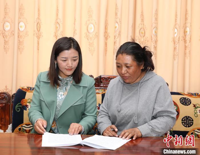 圖為扎囊養(yǎng)護(hù)段段長次旦卓瑪(左)正在與同事交流工作。　趙延 攝